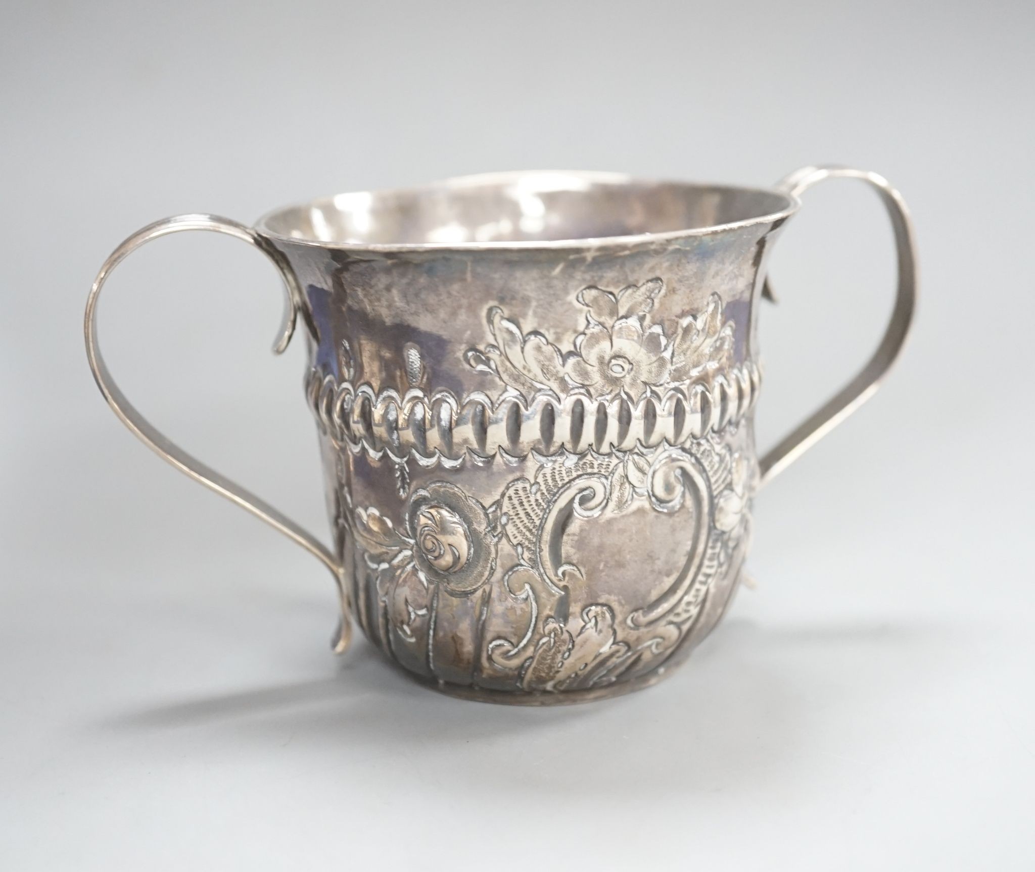 A George III embossed silver porringer, FM, London, 1766, 64mm, 79 grams.